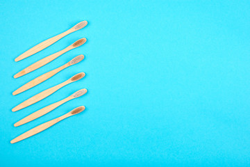 Bamboo toothbrushes on blue background. Plastic free concept. Place for text.