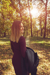 Portrait of beautiful elegant woman enjoying and posing in autumn day.