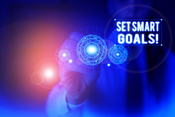 Text sign showing Set Smart Goals. Business photo showcasing list to clarify your ideas focus efforts use time wisely Woman wear formal work suit presenting presentation using smart device