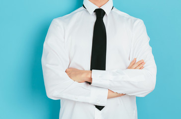 Businessman crossing his arms on blue background
