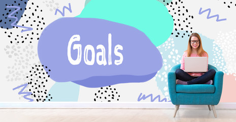 Goals with young woman using her laptop in a chair