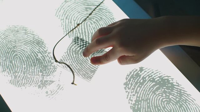 Children hands are checking the fingerprint at the school of forensics