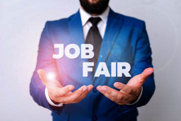 Text sign showing Job Fair. Business photo showcasing An event where a demonstrating can apply for a job in multiple companies Man with opened hands in fron of the table. Mobile phone and notes on the
