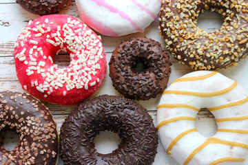 Various donuts on white background, from above. 