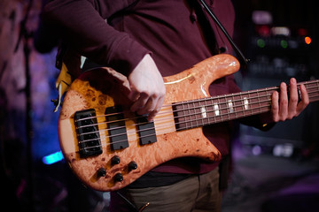 Obraz premium Rock band performs on stage. Guitarist, bass guitar and drums. The guitarist plays.