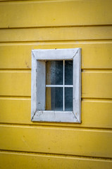 pequena janela de casa de madeira amarela e branca