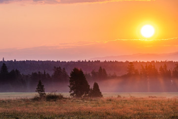Beautiful sunrise on Slovakian meadow, orange look, with clouds