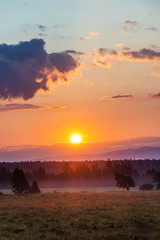 Obraz premium Beautiful sunrise on Slovakian meadow, orange look, with clouds