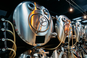 Beer kegs connected with pipes for beer serving at the bar in pub