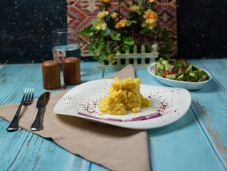 Mashed potatoes in bowl with onion on the table