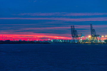sunrise at the marina with marine cranes visible