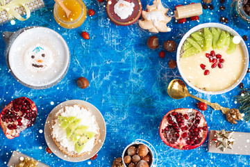 holiday breakfast, christmas or new year background with food coffee with marshmallows snowman and cookies christmas tree shap