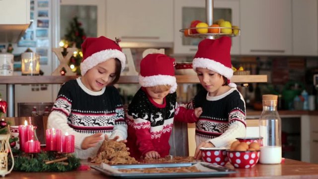 Happy children, boy brothers and mother, baking christmas cookies at home, having fun