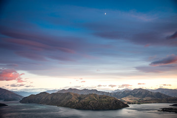 Fototapeta premium Sunrise sky mountain landscape. Early dawn morning colorful sky with scenic view over mountains in New Zealand. Roys Peak Wanaka