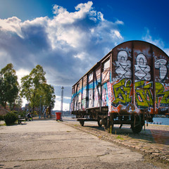 Abandoned railroad car in urban waterfront environment with grafitti