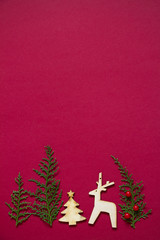 Naklejka na ściany i meble Treeline shape made of thuja branches and wooden figures of Christmas tree and deer. Minimal winter creative table flat lay