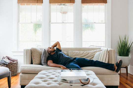 Man Resting On Couch At Home