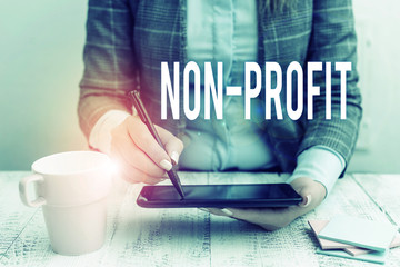 Writing note showing Non Profit. Business concept for providing products or service without paying...