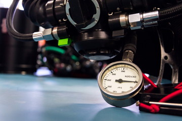 Gas pressure indicator, scuba diving oxygen lying on blue table background, copy space