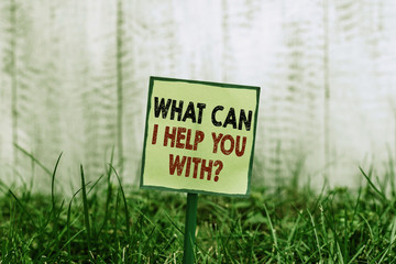 Conceptual hand writing showing What Can I Help You With Question. Concept meaning Offering assistance Experts advice ideas Plain paper attached to stick and placed in the grassy land