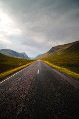 A long Scotland asphalt road in the middle of nowhere, heading towards brighter future