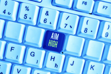 Word writing text Aim High. Business photo showcasing go for best job school or activity Asking someone to dream big White pc keyboard with empty note paper above white background key copy space