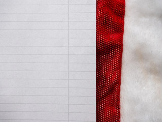 Christmas letter mock up. Top view, Empty paper sheet on a Santa Claus hat. Copy space.