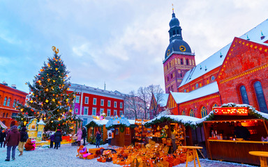 Cityscape with Christmas Market at Dome Cathedral square in Winter Riga, Latvia. Advent Fair Decoration and Stalls with Crafts Items on the Bazaar. Latvian street Xmas and holiday