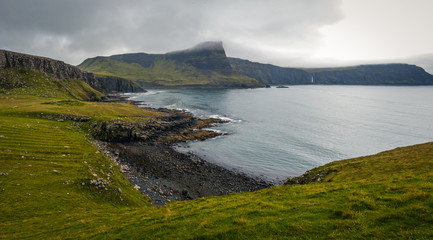 View on green grass filled coastal in Scotland near Nest Point famous lighthouse, Isle of Skye