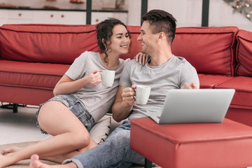 Happy young couple with laptop at home