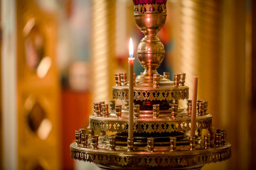 symbol of faith and Christianity: a candlestick with burning candles in the temple in darkness