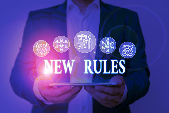 Writing note showing New Rules. Business concept for A state of changing an iplemented policy for better upgrade Male wear formal work suit presenting presentation smart device