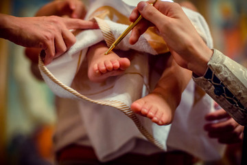 Church. To a little baby and a cross at the ceremony of baptism.Baptizing a child