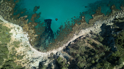 A beach by the sea or ocean, surrounded by cliffs and forests. Great places for traveling and outdoor recreation. Top view of the drone.