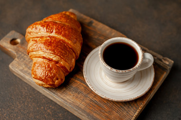 coffee and croissant on a stone table with copy space for your text, early breakfast concept
