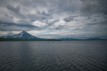 Fototapeta premium Panoramic view of the city Petropavlovsk-Kamchatsky and volcanoes: Koryaksky Volcano, Avacha Volcano, Kozelsky Volcano. Russian Far East, Kamchatka Peninsula.