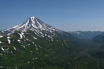 Panoramic view of the city Petropavlovsk-Kamchatsky and volcanoes: Koryaksky Volcano, Avacha Volcano, Kozelsky Volcano. Russian Far East, Kamchatka Peninsula.