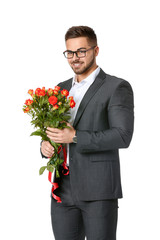 Handsome man with flowers on white background. Valentine's Day celebration