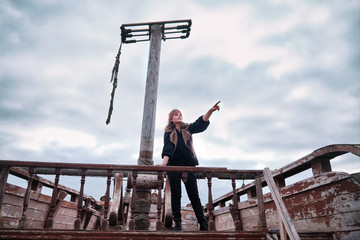 The girl is on board a pirate ship and shows the direction of the hand