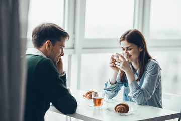 young couple having breakfast in the kitchen