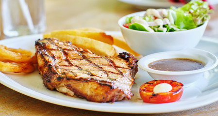thick pork steak with gravy, salad and hand cut fries