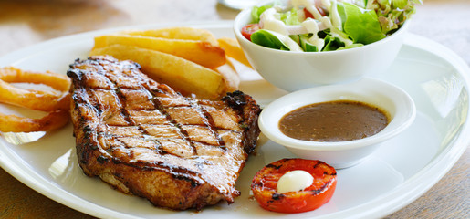 thick pork steak with gravy, salad and hand cut fries