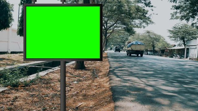 Street billboard green screen or chroma key with time lapse traffic background. Seamless loop for mock up advertisement