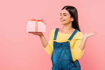 happy pregnant pretty girl holding gift box isolated on pink