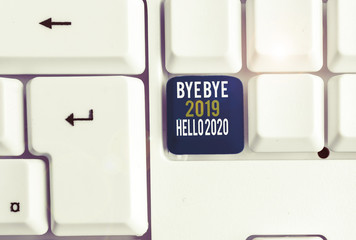 Conceptual hand writing showing Bye Bye 2019 Hello 2020. Concept meaning Starting new year Motivational message 2019 is over White pc keyboard with note paper above the white background © A