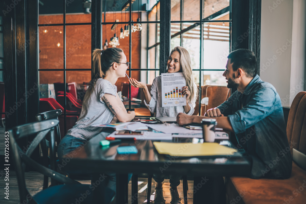 Wall mural delighted freelancer explaining charts to colleagues