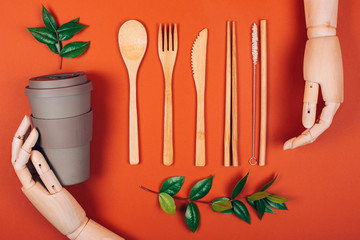 Wooden hand holding reusable picnic tableware. Concept of plastic-free and zero waste living