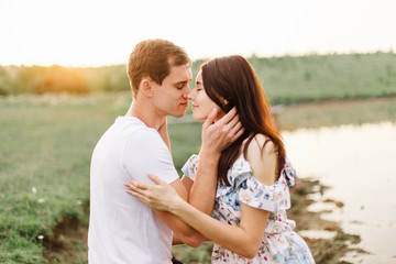 Portrait of happy couple outdoor in nature location at sunset.