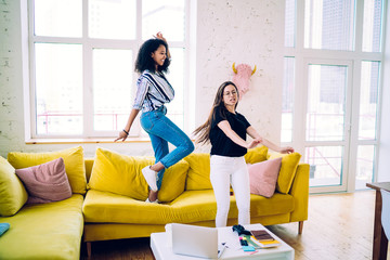 Joyful multiethnic friends dancing and having party at home