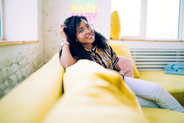 Cheerful woman sitting on couch at home